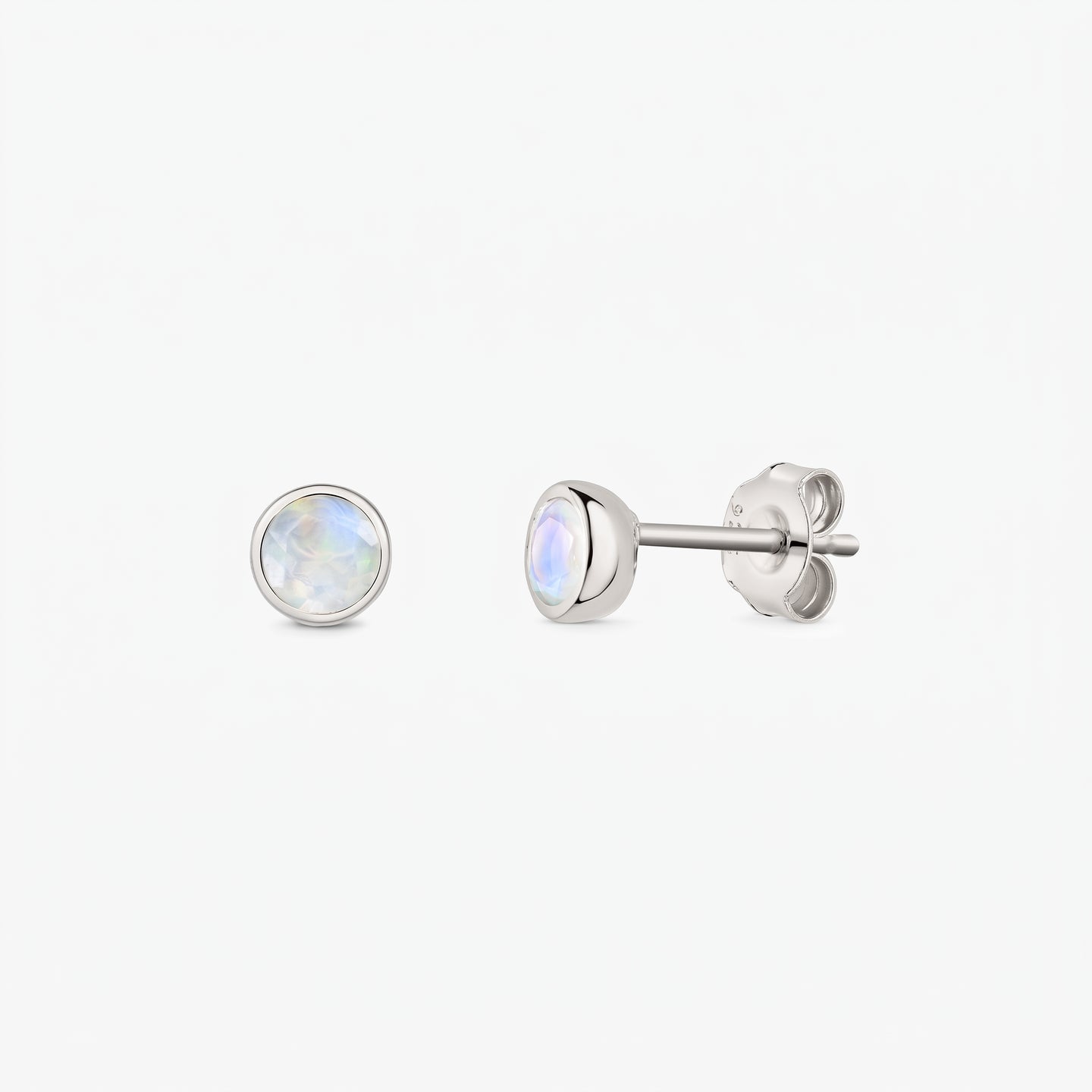 Pair of 925 sterling silver moonstone stud earrings on a white background, shown front and side with butterfly backs and bezel-set round iridescent stones.